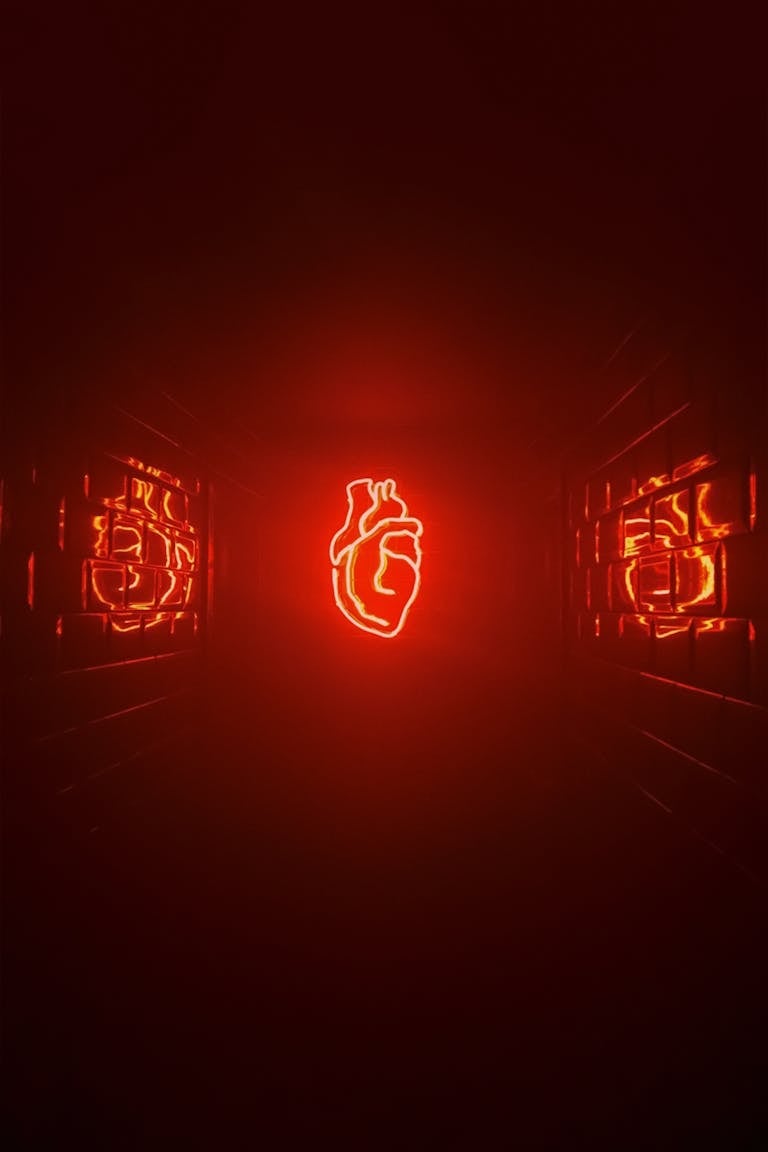 A vivid red neon heart glowing in a dark futuristic space with reflective surfaces.